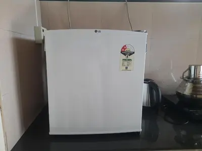 a white refrigerator in the corner of a kitchen at NEST Mdy in Mananthavady