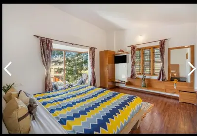 a bedroom with a large bed and a large window at Mysterious mountain in Ooty