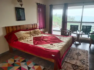 a bedroom with a bed and a large window at Mysterious mountain in Ooty