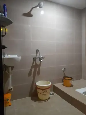 a bathroom with a sink and a toilet and a faucet at A Chettinad villa in Coimbatore on the way to Adiyogi and nearer to Maruthamalai in Coimbatore