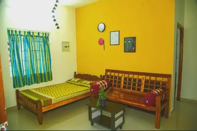 two beds in a room with yellow walls at A Chettinad villa in Coimbatore on the way to Adiyogi and nearer to Maruthamalai in Coimbatore