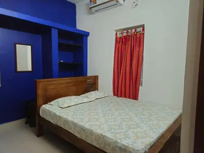 a bedroom with a bed and a red curtain at A Chettinad villa in Coimbatore on the way to Adiyogi and nearer to Maruthamalai in Coimbatore