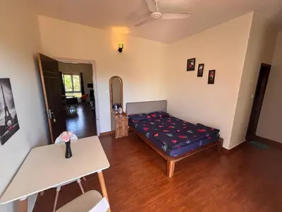a room with a bed and a table in it at Empra Exotica in Madikeri