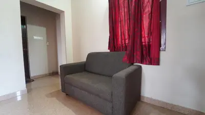 a chair in a room with a red curtain at Varun residency in Coimbatore