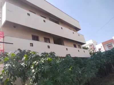 a white building with trees in front of it at Varun residency in Coimbatore