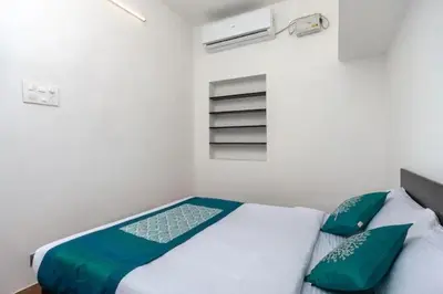 a bedroom with a bed with green and white pillows at Varun residency in Coimbatore