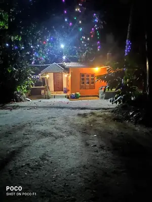 a house at night with lights in front of it at Golden Peak Estate Homestay in Wayanad