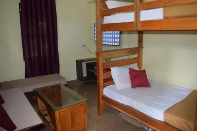 a small room with a bunk bed and a desk at Golden Peak Estate Homestay in Wayanad