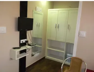 a small room with a tv and some cabinets at Hotel Mothimahal in Trichūr