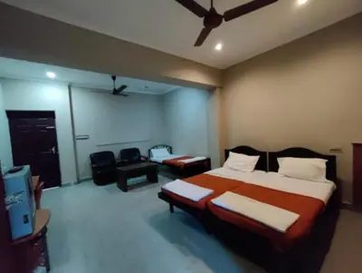 a bedroom with a bed and a flat screen tv at Hotel Mothimahal in Trichūr