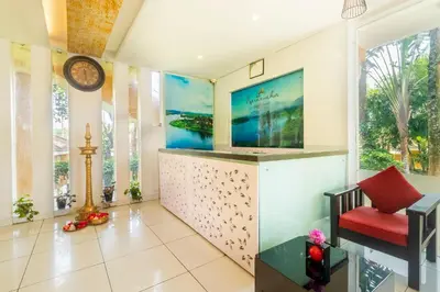 a living room with a tv and a red chair at Karapuzha Village Resort in Wayanad