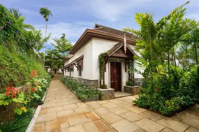 a house with a walkway in front of it at Taj Wayanad Resort & Spa, Kerala in Wayanad