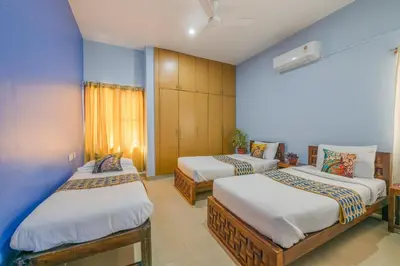 two beds in a room with blue walls at LikeMyVilla 3bedroom villa in Vānivilāsa Puram