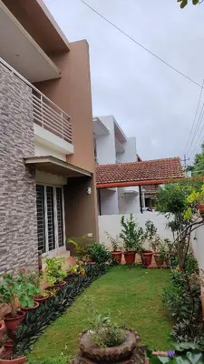 a house with a yard with potted plants at LikeMyVilla 3bedroom villa in Vānivilāsa Puram