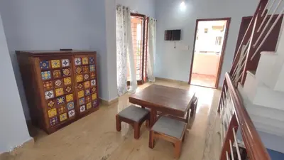 a dining room with a table and chairs and a cabinet at LikeMyVilla 3bedroom villa in Vānivilāsa Puram