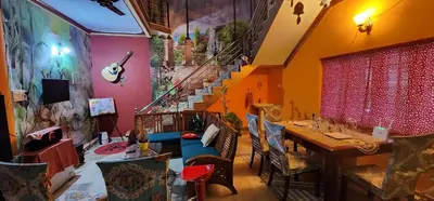 a room with a table and chairs and a staircase at JJ's White House in Trichūr
