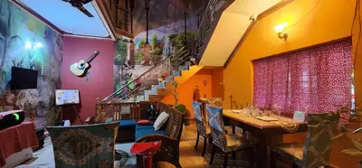 a dining room with a table and a staircase at JJ's White House in Trichūr