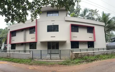 a white building with red trim next to a street at Shangri-laa hotel apartments in Tāzhekkod