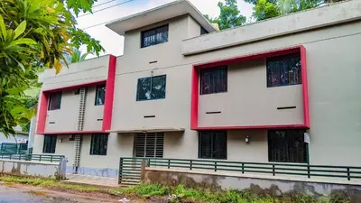 a white building with red trim at Shangri-laa hotel apartments in Tāzhekkod