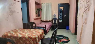 a room with two beds and a table and chairs at JJ's Holiday Home in Thanniyam
