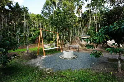 a park with a playground with a bench and a swing at Cave Valley Wayanad in Ambalavayal