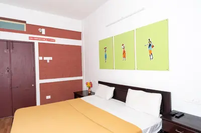a bedroom with a bed and paintings on the wall at Deepwoods Stay-Kinathukadavu, Coimbatore in Coimbatore