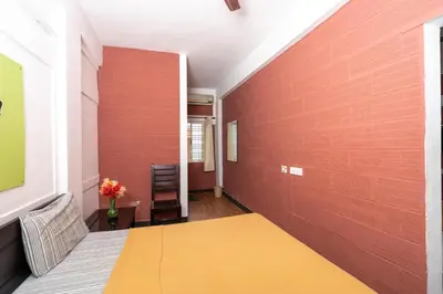 a room with a bed and a red brick wall at Deepwoods Stay-Kinathukadavu, Coimbatore in Coimbatore