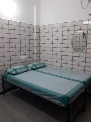 a small bedroom with a bed in a room at Lakshmi Paradise Lodge A/C in Pollāchi