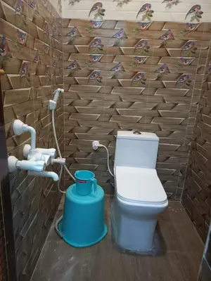 a bathroom with a toilet and a water tank at Lakshmi Paradise Lodge A/C in Pollāchi