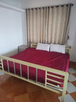 a bedroom with a large bed with a red blanket at The Orange Home in Kotagiri