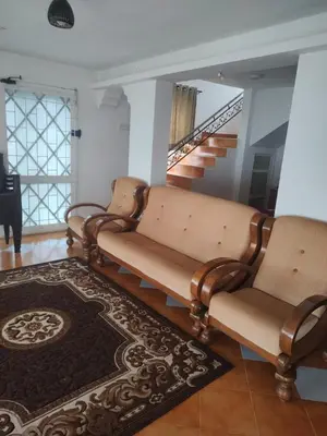 a living room with two chairs and a piano at The Orange Home in Kotagiri