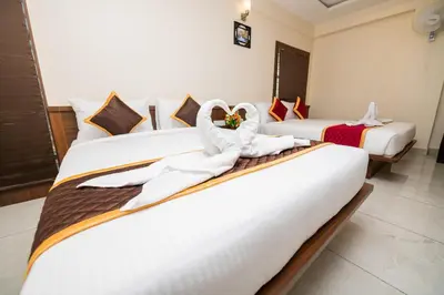 a hotel room with two beds with white sheets at KK Comforts in Shrīrangapattana