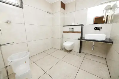 a bathroom with a toilet and a sink at KK Comforts in Shrīrangapattana