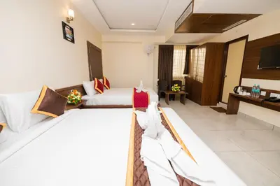a hotel room with two beds and a television at KK Comforts in Shrīrangapattana