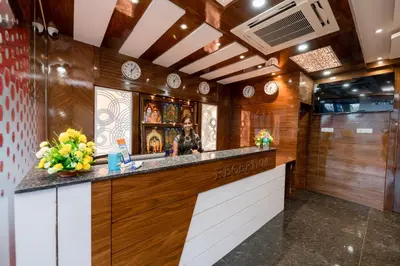 a kitchen with a bar with a woman standing at it at KK Comforts in Shrīrangapattana