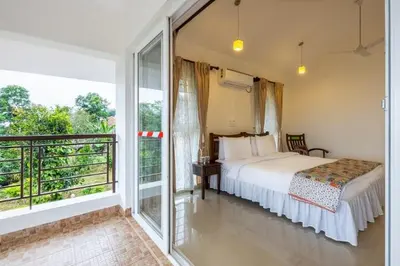 a bedroom with a bed and a balcony at ama Stays & Trails Arcadia, Coorg in Madikeri