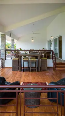 a living room with a table and chairs in a room at ama Stays & Trails Arcadia, Coorg in Madikeri