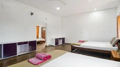 a large room with two beds and a table at Hatti Eden Coorg in Gonikoppal