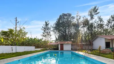a swimming pool in the backyard of a house at Hatti Eden Coorg in Gonikoppal