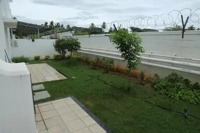 a backyard with a fence and a yard with trees at The best villa stay- family friendly in Coimbatore