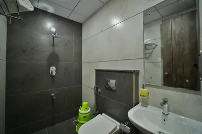 a bathroom with a sink and a toilet and a mirror at The Mysore Grand in Mysore