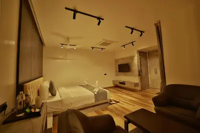 a bedroom with a bed and a living room at The Mysore Grand in Mysore