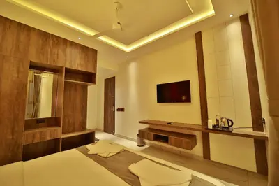 a bedroom with a bed and a tv on the wall at The Mysore Grand in Mysore