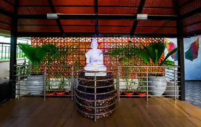 a statue sitting on top of a building with potted plants at Royal Tusker Luxury Service Apartments in Mysore
