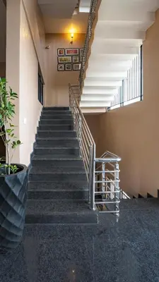 a set of stairs in a building with a stair case at Royal Tusker Luxury Service Apartments in Mysore
