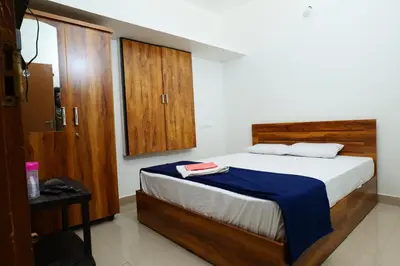 a bedroom with a bed with a blue blanket and wooden cabinets at Hillside Hideaway Gudalur in Gūdalūr