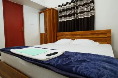 a bed with a blue blanket on top of it at Hillside Hideaway Gudalur in Gūdalūr