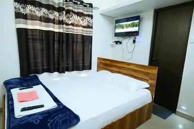a bedroom with a bed with a tv on the wall at Hillside Hideaway Gudalur in Gūdalūr