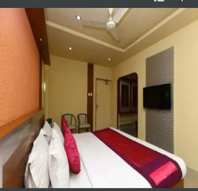 a bedroom with a bed with red and white pillows at NavaRATNA Delight in Coimbatore