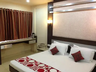 a bedroom with a large bed with red and white pillows at NavaRATNA Delight in Coimbatore